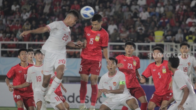 Striker Timnas Indonesia U-16, Josh Holong Junior (20) berduel udara dengan pemain Laos dalam pertandingan ketiga Grup A Piala AFF U-16 2024 di Stadion Manahan, Solo, Kamis (27/6/2024). [Suara.com / Ronald Seger Prabowo]