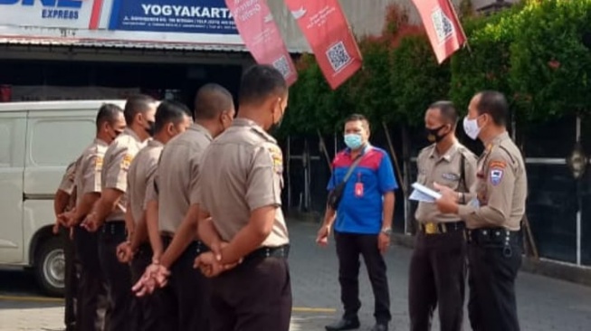 Arif dan tim pengamanan dari Kantor JNE Yogyakarta mengadakan briefing sebelum bertugas [Suara.com/Dok Pribadi/Rizqi]