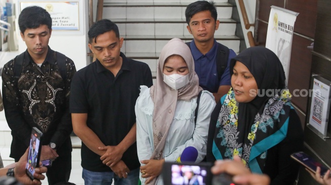 Ibunda Afif Maulana, Anggun Andriani (tengah)  menunjukkan foto anaknya saat usai melakukan audiensi di kantor Komnas HAM, Jakarta, Senin (1/7/2024). [Suara.com/Alfian Winanto]