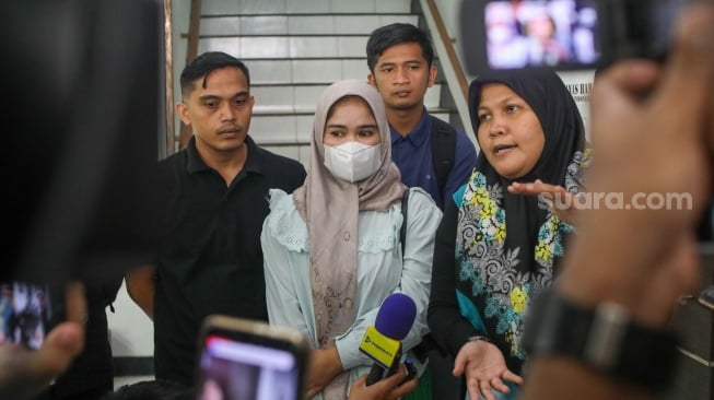 Ibunda Afif Maulana, Anggun Andriani (tengah)  menunjukkan foto anaknya saat usai melakukan audiensi di kantor Komnas HAM, Jakarta, Senin (1/7/2024). [Suara.com/Alfian Winanto]