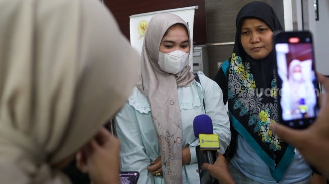 Ibunda Afif Maulana, Anggun Andriani (tengah)  menunjukkan foto anaknya saat usai melakukan audiensi di kantor Komnas HAM, Jakarta, Senin (1/7/2024). [Suara.com/Alfian Winanto]