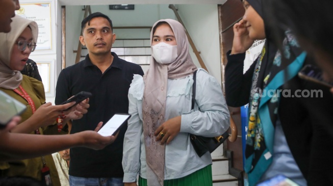 Ibunda Afif Maulana, Anggun Andriani (tengah)  menunjukkan foto anaknya saat usai melakukan audiensi di kantor Komnas HAM, Jakarta, Senin (1/7/2024). [Suara.com/Alfian Winanto]