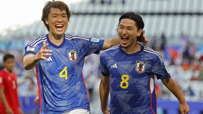 Gelandang serang Timnas Jepang, Takumi Minamino (kanan). [KARIM JAAFAR / AFP]