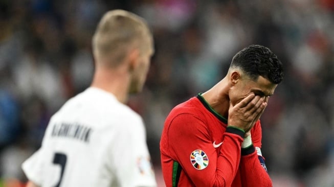 Reaksi penyerang timnas Portugal, Cristiano Ronaldo setelah gagal mencetak gol lewat tendangan penalti pada pertandingan babak 16 besar Euro 2024 antara Portugal vs Slovenia di Frankfurt Arena di Frankfurt am Main pada 1 Juli 2024.PATRICIA DE MELO MOREIRA / AFP.