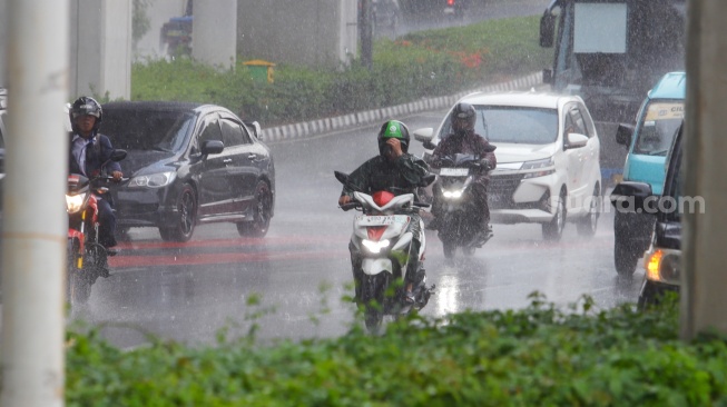 Pengendara motor melintas saat hujan lebat di Jalan Gatot Subroto, Jakarta, Selasa (2/7/2023). [Suara.com/Alfian Winanto]