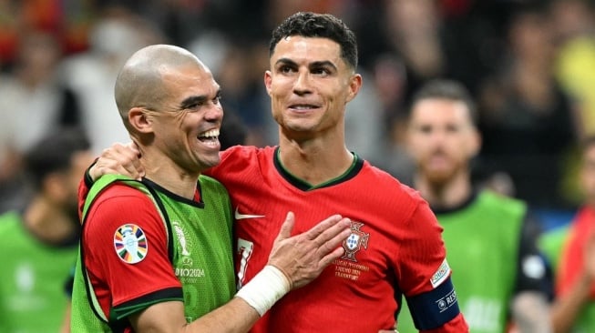 Penyerang timnas Portugal, Cristiano Ronaldo (kanan) dan bek Portugal Pepe melakukan selebrasi setelah membantu timnya menang atas Slovenia lewat drama adu penalti setelah bermain 0-0 di babak 16 besar Euro 2024 di Frankfurt Arena di Frankfurt am Main pada 1 Juli 2024.PATRICIA DE MELO MOREIRA / AFP.