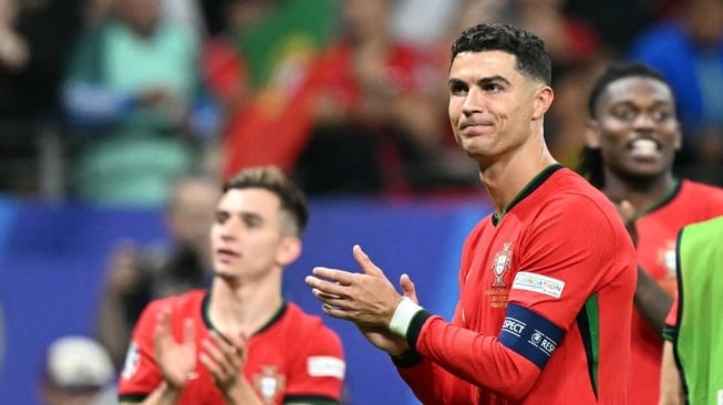 Penyerang timnas Portugal, Cristiano Ronaldo melakukan selebrasi setelah memenangkan pertandingan babak 16 besar Euro 2024 antara Portugal vs Slovenia di Frankfurt Arena di Frankfurt am Main pada 1 Juli 2024.PATRICIA DE MELO MOREIRA / AFP.