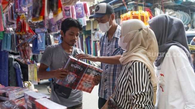 Warga memilih buku sekolah di Toko Seragam di Pasar Jatinegara, Jakarta, Selasa (2/7/2024). [Suara.com/Alfian Winanto]