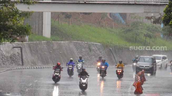 Pengendara motor melintas saat hujan lebat di Jalan Gatot Subroto, Jakarta, Selasa (2/7/2023). [Suara.com/Alfian Winanto]