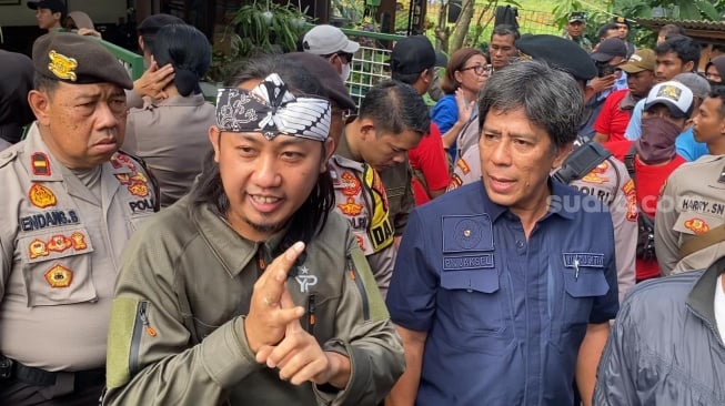 Aksi komedian Ade Jigo jadi juru bicara warga terdampak eksekusi lahan di wilayah kediamannya kawasan Lebak Bulus, Jakarta, Kamis (4/7/2024). [Suara.com/Adiyoga Priyambodo]