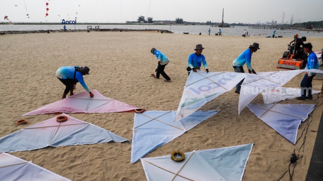 Peserta menerbangkan layang-layang saat mengikuti Festival Layang-layang Internasional 2024 di Pantai Lagoon, Taman Impian Jaya Ancol, Jakarta, Kamis (4/7/2024). [Suara.com/Alfian Winanto]