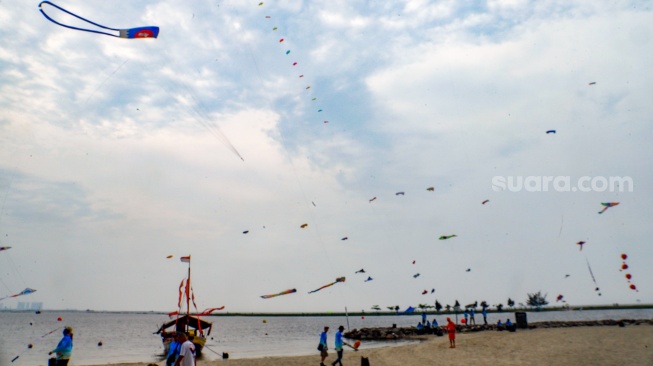 Peserta menerbangkan layang-layang saat mengikuti Festival Layang-layang Internasional 2024 di Pantai Lagoon, Taman Impian Jaya Ancol, Jakarta, Kamis (4/7/2024). [Suara.com/Alfian Winanto]