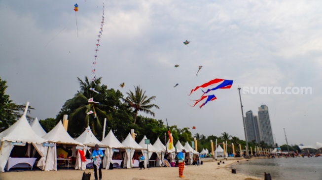 Peserta menerbangkan layang-layang saat mengikuti Festival Layang-layang Internasional 2024 di Pantai Lagoon, Taman Impian Jaya Ancol, Jakarta, Kamis (4/7/2024). [Suara.com/Alfian Winanto]