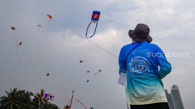 Peserta menerbangkan layang-layang saat mengikuti Festival Layang-layang Internasional 2024 di Pantai Lagoon, Taman Impian Jaya Ancol, Jakarta, Kamis (4/7/2024). [Suara.com/Alfian Winanto]