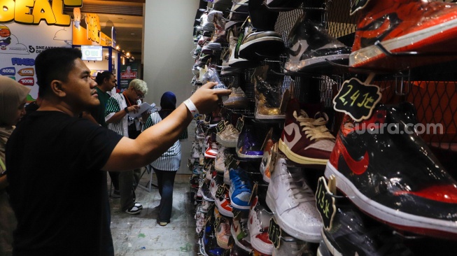 Pengunjung melihat produk sepatu dalam pameran Jakarta Sneaker Day (JSD) 2024 di Jakarta Convention Center (JCC), Senayan, Jakarta, Jumat (5/7/2024). [Suara.com/Alfian Winanto]