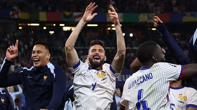 Penyerang Prancis Olivier Giroud (tengah) dan penjaga gawang Prancis Alphonse Areola (kiri) merayakan setelah memenangkan pertandingan sepak bola perempat final UEFA Euro 2024 antara Portugal dan Prancis di Volksparkstadion di Hamburg pada 5 Juli 2024.FRANCK FIFE / AFP