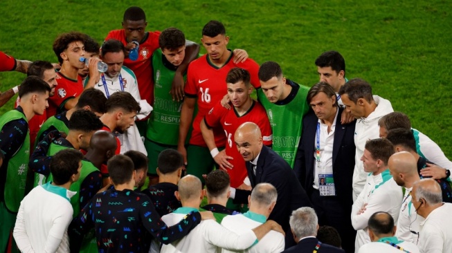 Pelatih kepala Portugal Roberto Martinez berbicara dengan para pemainnya sebelum adu penalti selama pertandingan sepak bola perempat final UEFA Euro 2024 antara Portugal dan Prancis di Volksparkstadion di Hamburg pada 5 Juli 2024.ANDERSEN Aneh / AFP