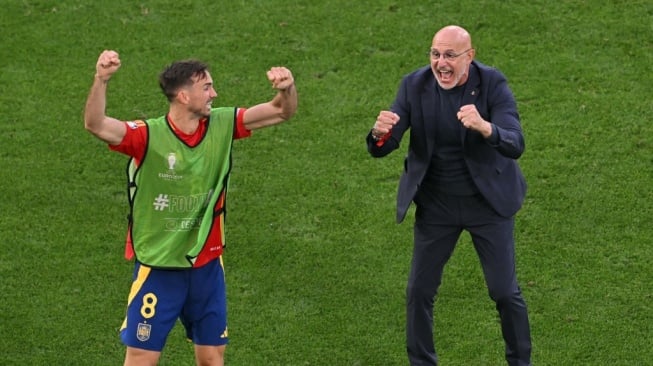 Gelandang Spanyol Fabian Ruiz dan pelatih kepala Spanyol Luis de la Fuente merayakan setelah memenangkan akhir pertandingan sepak bola perempat final UEFA Euro 2024 antara Spanyol dan Jerman di Stuttgart Arena di Stuttgart pada 5 Juli 2024.MIGUEL MEDINA / AFP