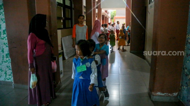 Sejumlah siswa berbaris untuk masuk kelas saat menjalani Masa Pengenalan Lingkungan Sekolah (MPLS) di Sekolah Dasar Negeri (SDN) 01 & 03 Kramat, Jakarta, Senin (8/7/2024). [Suara.com/Alfian Winanto]