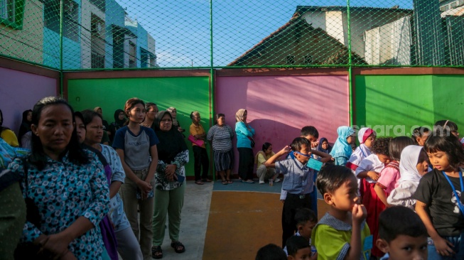 Sejumlah siswa ditemani orang tuanya saat menjalani Masa Pengenalan Lingkungan Sekolah (MPLS) di Sekolah Dasar Negeri (SDN) 01 & 03 Kramat, Jakarta, Senin (8/7/2024). [Suara.com/Alfian Winanto]