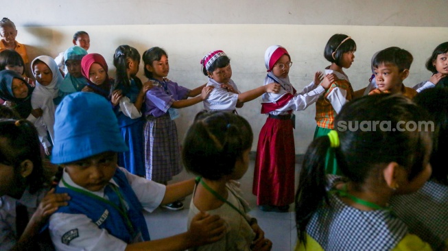 Sejumlah siswa berbaris untuk masuk kelas saat menjalani Masa Pengenalan Lingkungan Sekolah (MPLS) di Sekolah Dasar Negeri (SDN) 01 & 03 Kramat, Jakarta, Senin (8/7/2024). [Suara.com/Alfian Winanto]