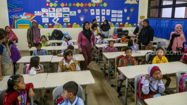 Sejumlah siswa ditemani orang tuanya saat menjalani Masa Pengenalan Lingkungan Sekolah (MPLS) di Sekolah Dasar Negeri (SDN) 01 & 03 Kramat, Jakarta, Senin (8/7/2024). [Suara.com/Alfian Winanto]