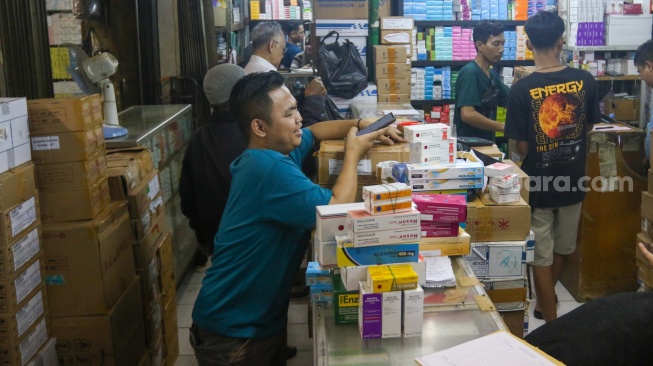 Warga membeli produk obat-obatan yang dijual di Pasar Pramuka, Jakarta, Selasa (9/7/2024). [Suara.com/Alfian Winanto]