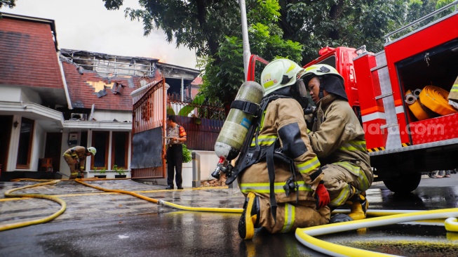 Petugas Pemadam Kemabakaran berusaha memadamkan api yang membakar rumah mewah di Kawasan Menteng, Jakarta, Selasa (9/7/2024). [Suara.com/Alfian Winanto]