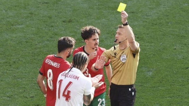 Bek Turki, Abdulkerim Bardakci, menerima kartu kuning oleh wasit Jerman Felix Zwayer selama pertandingan Grup F Euro 2024 antara Turki vs Portugal di BVB Stadion di Dortmund pada 22 Juni 2024. (Kenzo Tribouillard/AFP)