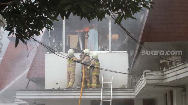 Petugas Pemadam Kemabakaran berusaha memadamkan api yang membakar rumah mewah di Kawasan Menteng, Jakarta, Selasa (9/7/2024). [Suara.com/Alfian Winanto]