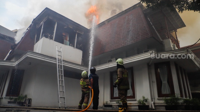 Petugas Pemadam Kemabakaran berusaha memadamkan api yang membakar rumah mewah di Kawasan Menteng, Jakarta, Selasa (9/7/2024). [Suara.com/Alfian Winanto]