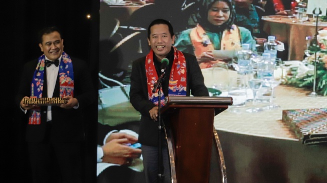 Pemimpin Redaksi Suara.com, Suwarjono (tengah) memberikan pidato usai menerima penghargaan saat acara Gala Dinner 50 Tahun Hotel Aryaduta Menteng di Jakarta, Jumat (12/7/2024). [Suara.com/Alfian Winanto]