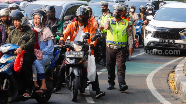 Sejumlah petugas kepolisian memberikan himbauan kepada pengendara yang melanggar peraturan saat Operasi Patuh Jaya 2024 di Jalan Letjen S Parman, Jakarta, Senin (15/07/2024). [Suara.com/Alfian Winanto]