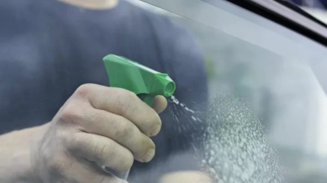 Pembersihan kaca dalam mobil dengan microfiber dan glass cleaner bebas garis streak penting untuk visibility malam hari