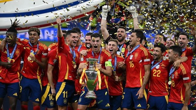 Penyerang Spanyol Alvaro Morata (tengah) berselebrasi mengangkat trofi bersama para pemain Spanyol setelah memenangkan pertandingan sepak bola Final Euro 2024 antara Spanyol dan Inggris di Olympiastadion, Berlin, Jerman, Minggu (14/7/2024). [JAVIER SORIANO / AFP]