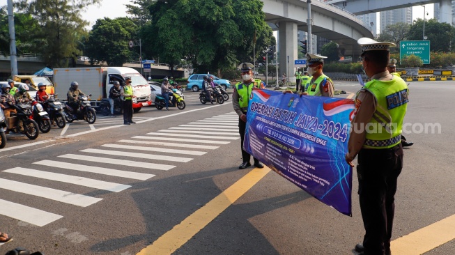 Sejumlah petugas kepolisian memberikan himbauan kepada pengendara yang melanggar peraturan saat Operasi Patuh Jaya 2024 di Jalan Letjen S Parman, Jakarta, Senin (15/07/2024). [Suara.com/Alfian Winanto]