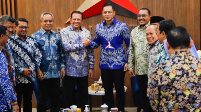 Ketua MPR RI Bambang Soesatyo dan Ketua Umum Partai Demokrat Agus Harimurti Yudhoyono (tengah) berjabat tangan saat melakukan pertemuan di kantor DPP Demokrat, Jakarta, Selasa (16/7/2024). [Suara.com/Alfian Winanto]