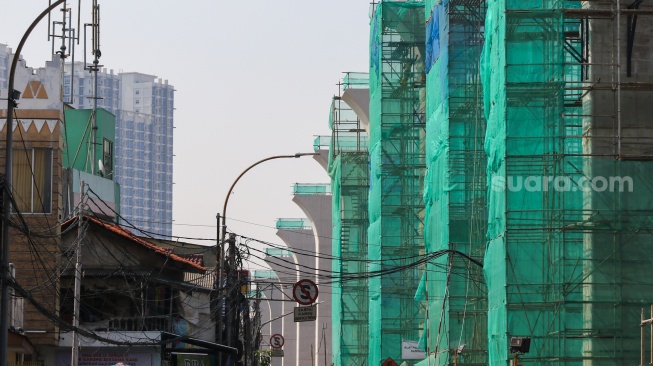 Pekerja menyelesaikan pembangunan proyek LRT Jakarta Fase 1B di kawasan Manggarai, Jakarta, Rabu (17/7/2024). [Suara.com/Alfian Winanto]