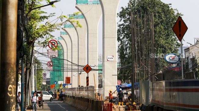 Pekerja menyelesaikan pembangunan proyek LRT Jakarta Fase 1B di kawasan Manggarai, Jakarta, Rabu (17/7/2024). [Suara.com/Alfian Winanto]
