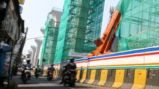 Pekerja menyelesaikan pembangunan proyek LRT Jakarta Fase 1B di kawasan Manggarai, Jakarta, Rabu (17/7/2024). [Suara.com/Alfian Winanto]
