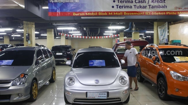 Pengunjung melihat mobil bekas yang dijual di bursa mobil bekas Blok M, Jakarta, Jumat (19/7/2024). [Suara.com/Alfian Winanto]