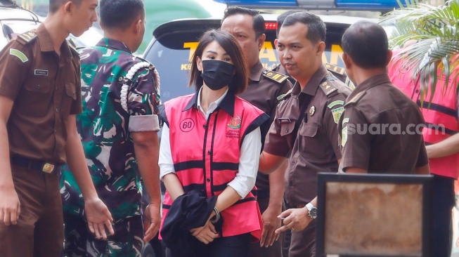 Tersangka kasus dugaan korupsi di PT Timah Helena Lim (tengah) berjalan memasuki gedung saat pelimpahan tahap dua di Kejaksaan Negeri Jakarta Selatan, Jakarta, Senin (22/7/2024). [Suara.com/Alfian Winanto]