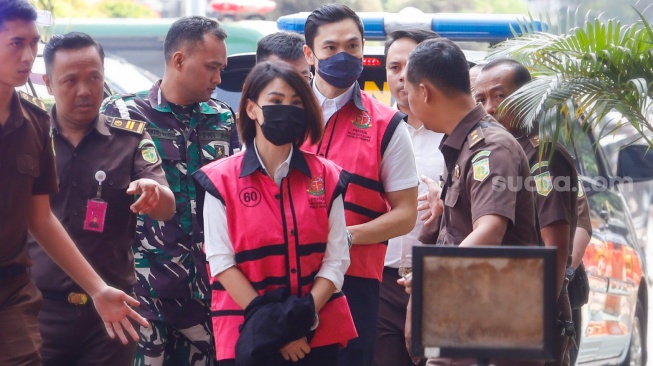 Tersangka kasus dugaan korupsi di PT Timah Harvey Moeis (kedua kanan) bersama Helena Lim (tengah) berjalan memasuki gedung saat pelimpahan tahap dua di Kejaksaan Negeri Jakarta Selatan, Jakarta, Senin (22/7/2024). [Suara.com/Alfian Winanto]