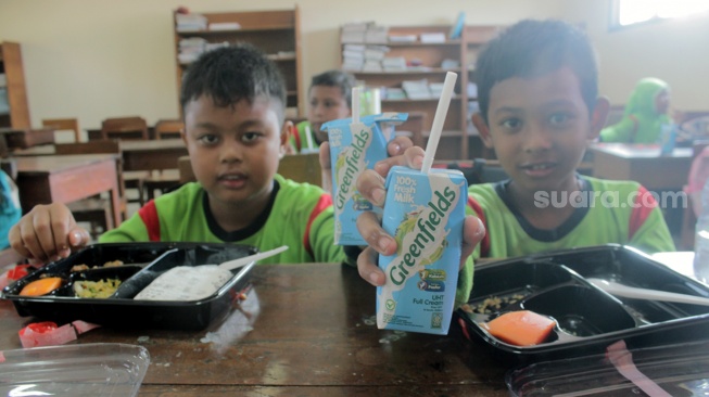 Siswa dan siswi SDN Tugu Solo menikmati menu makan siang gratis dalam uji coba yang berlangsung, Kamis (25/7/2024). Makan bergizi gratis yang merupakan program pasangan presiden dan wakil presiden terpilih, Prabowo Subianto-Gibran Rakabuming Raka.[Suara.com/Ronald Seger Prabowo]