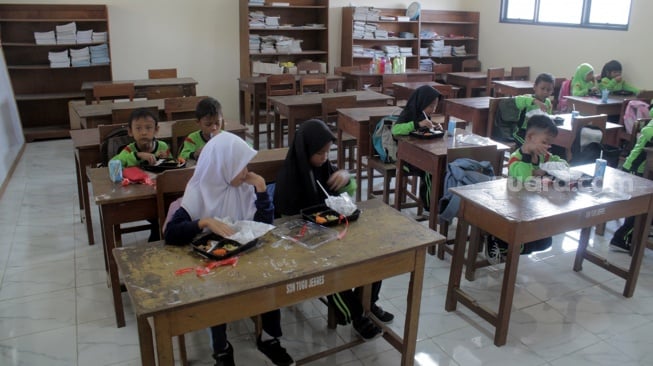 Siswa dan siswi SDN Tugu Solo menikmati menu makan siang gratis dalam uji coba yang berlangsung, Kamis (25/7/2024). Makan bergizi gratis yang merupakan program pasangan presiden dan wakil presiden terpilih, Prabowo Subianto-Gibran Rakabuming Raka.[Suara.com/Ronald Seger Prabowo]