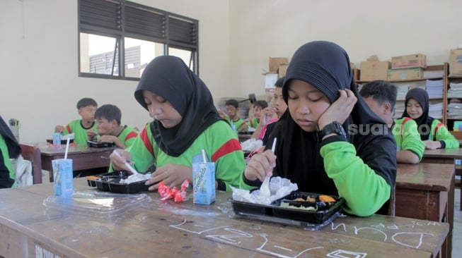 Siswa dan siswi SDN Tugu Solo menikmati menu makan siang gratis dalam uji coba yang berlangsung, Kamis (25/7/2024). Makan bergizi gratis yang merupakan program pasangan presiden dan wakil presiden terpilih, Prabowo Subianto-Gibran Rakabuming Raka.[Suara.com/Ronald Seger Prabowo]