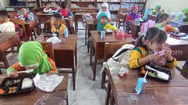 Siswa SD Tugu Solo saat menikmati menu dari program makan bergizi gratis, Kamis (25/7/2024). [Suara.com/Ari Welianto]