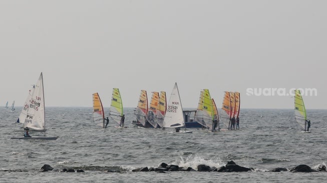 Sejumlah atlet layar beradu kecepatan saat mengikuti pertandingan Jakarta International Sailing Championship 2024 di area Symphony of The Sea, Ancol, Jakarta, Jumat (26/7/2024). [Suara.com/Alfian Winanto]
