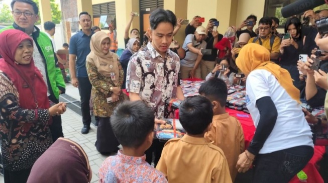 Wapres terpilih Gibran Rakabuming Raka saat membagikan makan siang kepada para siswa SDN Tugu Solo, Jawa Tengah, Jumat (26/7/2024). (ANTARA/Aris Wasita)