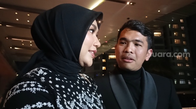 Putra Siregar dan istri, Septia Yetri Opani usai menghadiri pernikahan Thariq Halilintar dan Aaliyah Massaid di Hotel Raffles, Kuningan, Jakarta Selatan pada Jumat (26/7/2024)